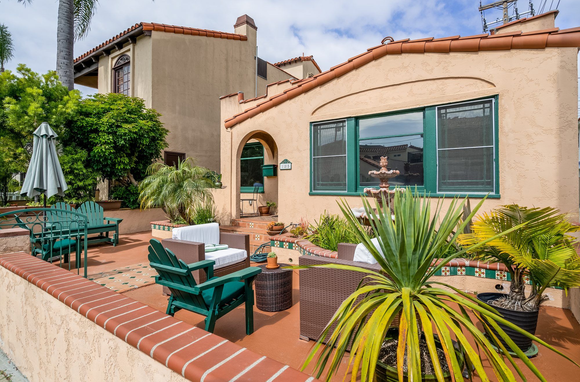 Spanish-style home with a tiled front patio and green-trimmed windows — a Southern California listing represented by The Chavez Team at The Agency
